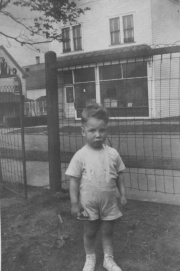 Ludwig Kapusta's butcher shop (as seen in the background.  Ludwig's grandson, James, age 3, in the foreground.