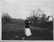 Mary Stanton Fish standing at the edge of the ravine.  The footbridge mentioned on this page is visible in the background.  A couple of people are standing on the bridge.Photo courtesy of Nora Bouvier, Mary's granddaughter.